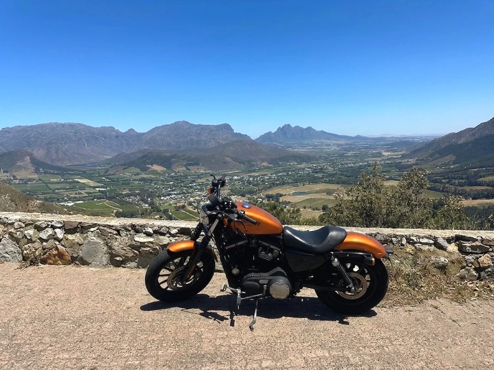 Moto face aux vignobles et aux montagnes du Cap